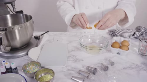 Time lapse. Scooping Italian buttercream frosting into piping bags with metal tips.