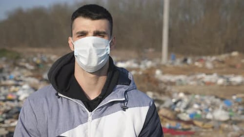 Adult Wearing Face Mask in Trash-Filled Landscape
