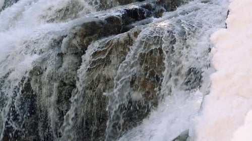 Slow Motion Snowy Waterfall Following White Water Over Rocks And Ice