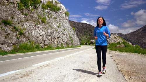 Smiling Jogger Runs Along Mountain