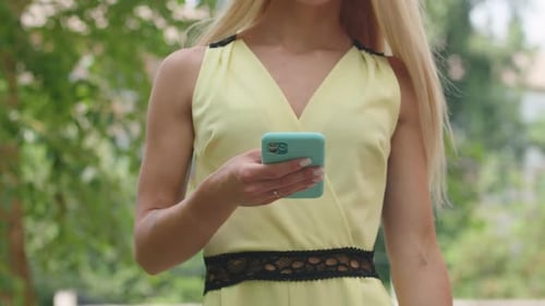 Woman Using Smartphone Outdoors on Summer Day