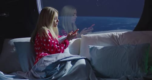 Femme utilisant un smartphone dans un vaisseau spatial