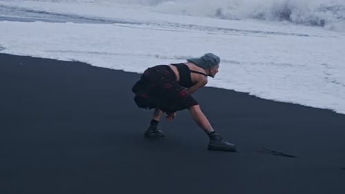 Cool Girl Dodging Surf On Black Sand Beach