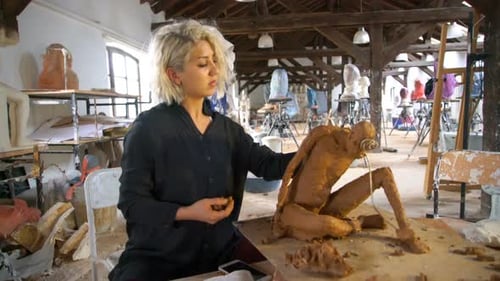Sculptor is Sculpting a Realistic, Figurative Model in Large Studio