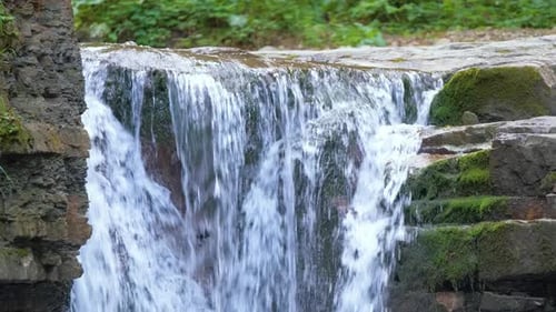 Waterfall on Mountain River with White Foamy Water Falling Down From Rocky Formation in Summer