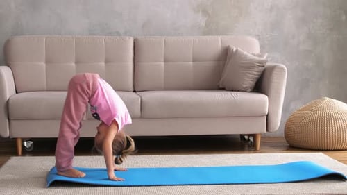 Girl Doing Yoga Exercises on Mat at Home