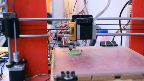 3D Printer Prints Green Object in Workplace