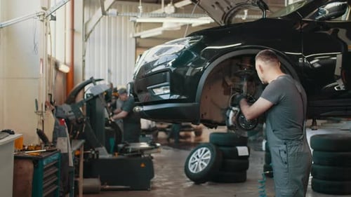 Portrait Shot of a Mechanic Working on a Vehicle in a Car Service
