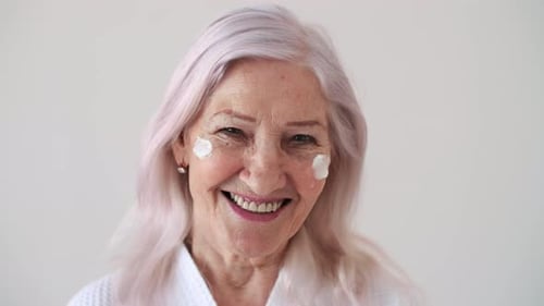 Smiling Senior Woman with Cream on Face