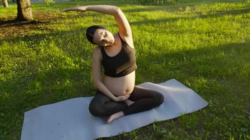 Pregnant Woman Doing Yoga in Park During Daytime