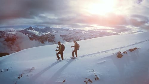 Two Hikers Walking Together Outdoors in Deep Snow Mountain Landscape