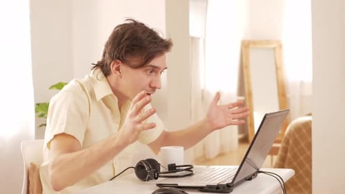 Young Man at Home Works with Laptop Cryptocurrency Stock Market