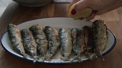 Grilled Sardines Drizzled with Lemon on Plate