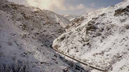Snowy Mountain Pass with Car Driving Through