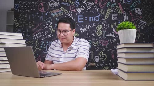 Man Giving Online Lesson at Desk with Laptop