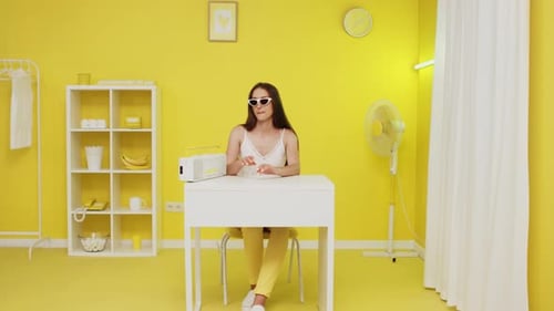 Young Woman Is Listening Music In Yellow Office