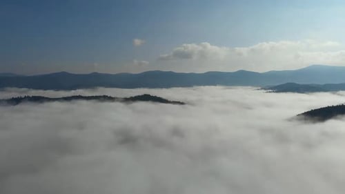 Aerial drone shot of amazing dense fog above river between mountains.