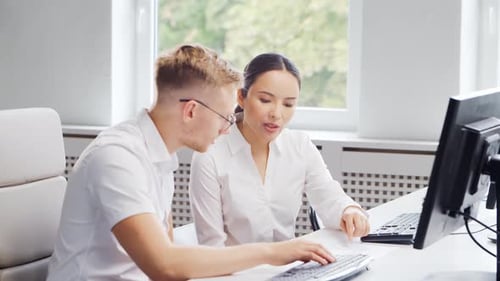 Diverse team of young professionals is working in the phone support office.