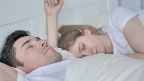 Pareja durmiendo en la cama