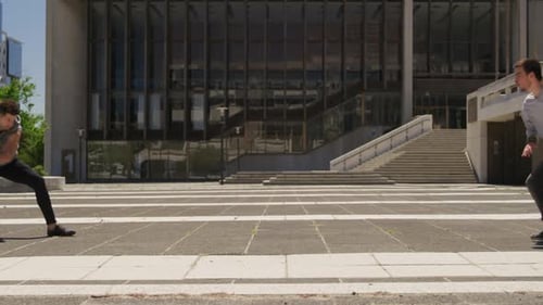 Young Adults Perform Synchronized Acrobatics in a City Plaza