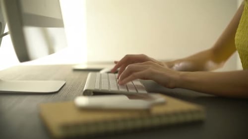 Hands Typing on Keyboard at Office Desk