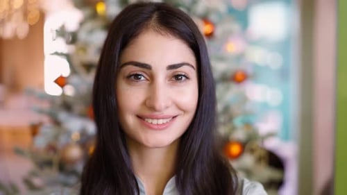 Woman Smiling near Christmas Tree Indoors