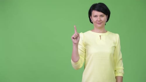 Woman Raising Index Finger on Green Background