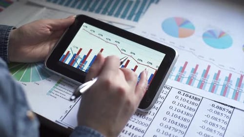 Analyst Examining Data Charts on a Tablet
