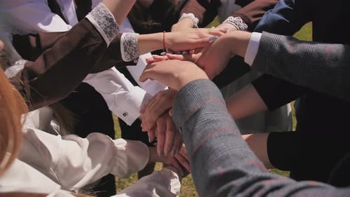 The Concept of Friendly Friends and Teamwork. Cheerful Friends Join Hands in the Center and Scatter.