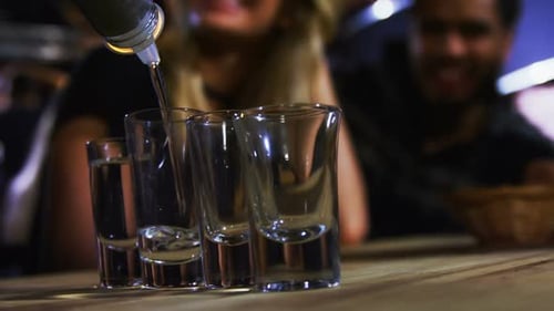 Bartender tequila in shot glasses in bar