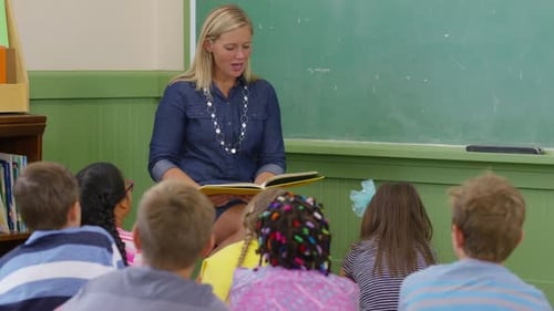 Teacher reads book to kids in school classroom