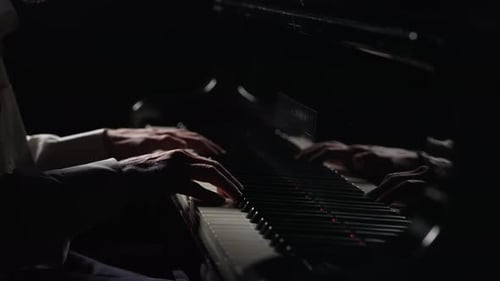 Person Plays Piano in the Darkness