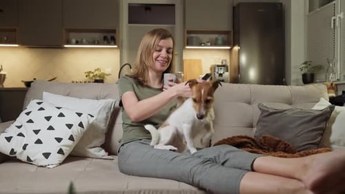 Woman Relaxing on Couch With Her Pet Dog