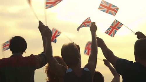 People Waving British Flags at Sunset