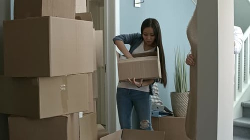 Young Couple Moving Into New Home With Boxes