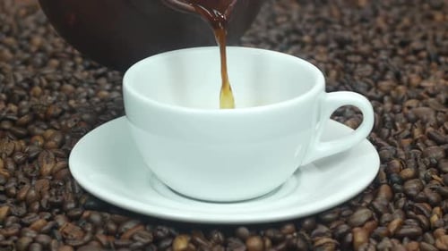 Pouring Black Coffee Into a White Cup