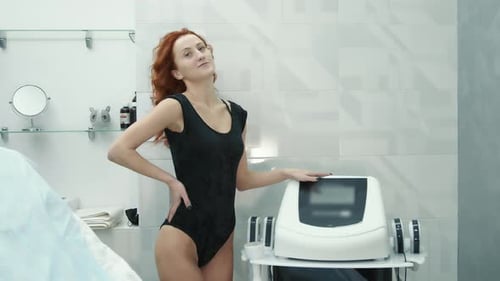 Woman in Black Bodysuit Posing in Medical Room
