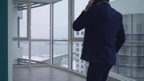Man in Suit Talking on Phone in Modern Apartment