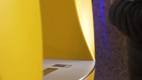 Man Using a Credit Card in an Atm for Cash Withdrawal