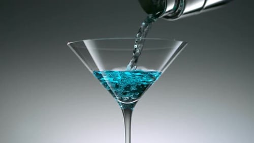 Blue Cocktail Being Poured Into Martini Glass