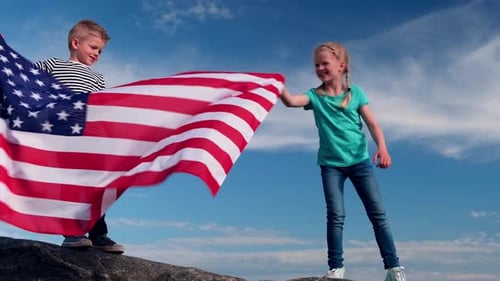 Boy and Girl Holding American Flag on Hilltop
