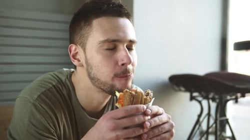 Man Eating Sandwich Indoors Close Up