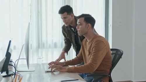 Men Collaborating on Computer Project in Office