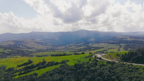 Aerial Flight Over a Mountain Road with Car Traffic That Climbs a Serpentine in the Mountains on a