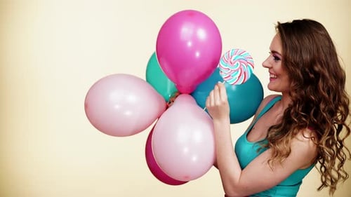 Young Woman with Balloons and Lollipop Candy
