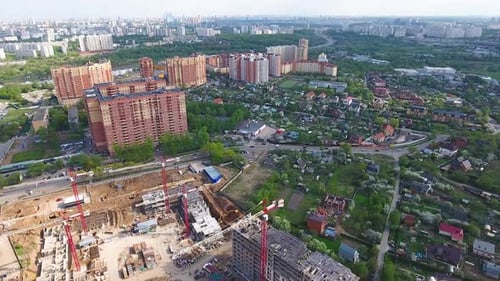 Drohne fliegt über eine Baustelle in der Nähe von Moskau. Baukrane im Industriegebiet.