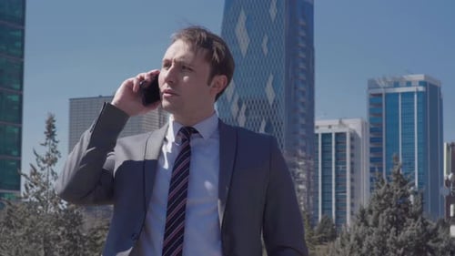 Young Adult Businessman Talking on Phone in City