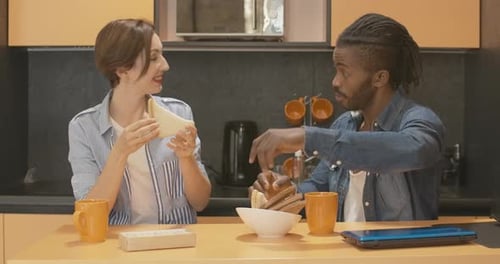 Couple Enjoying Breakfast Sandwiches Together in Kitchen