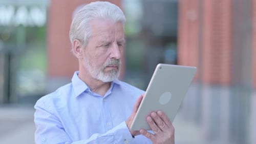 Senior Man Using Tablet Outdoors in City
