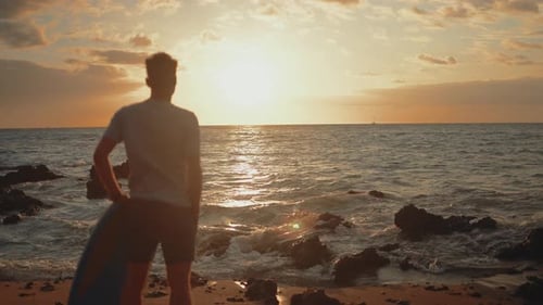 Surfer Contemplates Ocean at Colorful Sunset